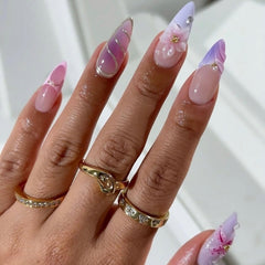 Uñas postizas LPOODDNU en forma almendra con flor 3D y perlas para un look elegante.