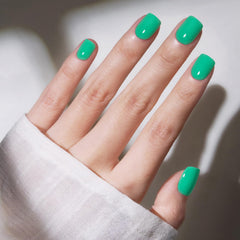Modelones uñas presión verde vivo en mano, aplicación rápida para un look diario.
