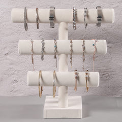 Pangkeep expositor de joyas para brazaletes con exterior de terciopelo beige.