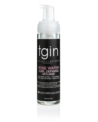 Mousse tgin para definición de rizos con agua de rosa en botella clara.