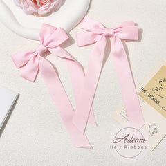 Detalle texturizado del lazo rosa de AILEAM, tacto suave.