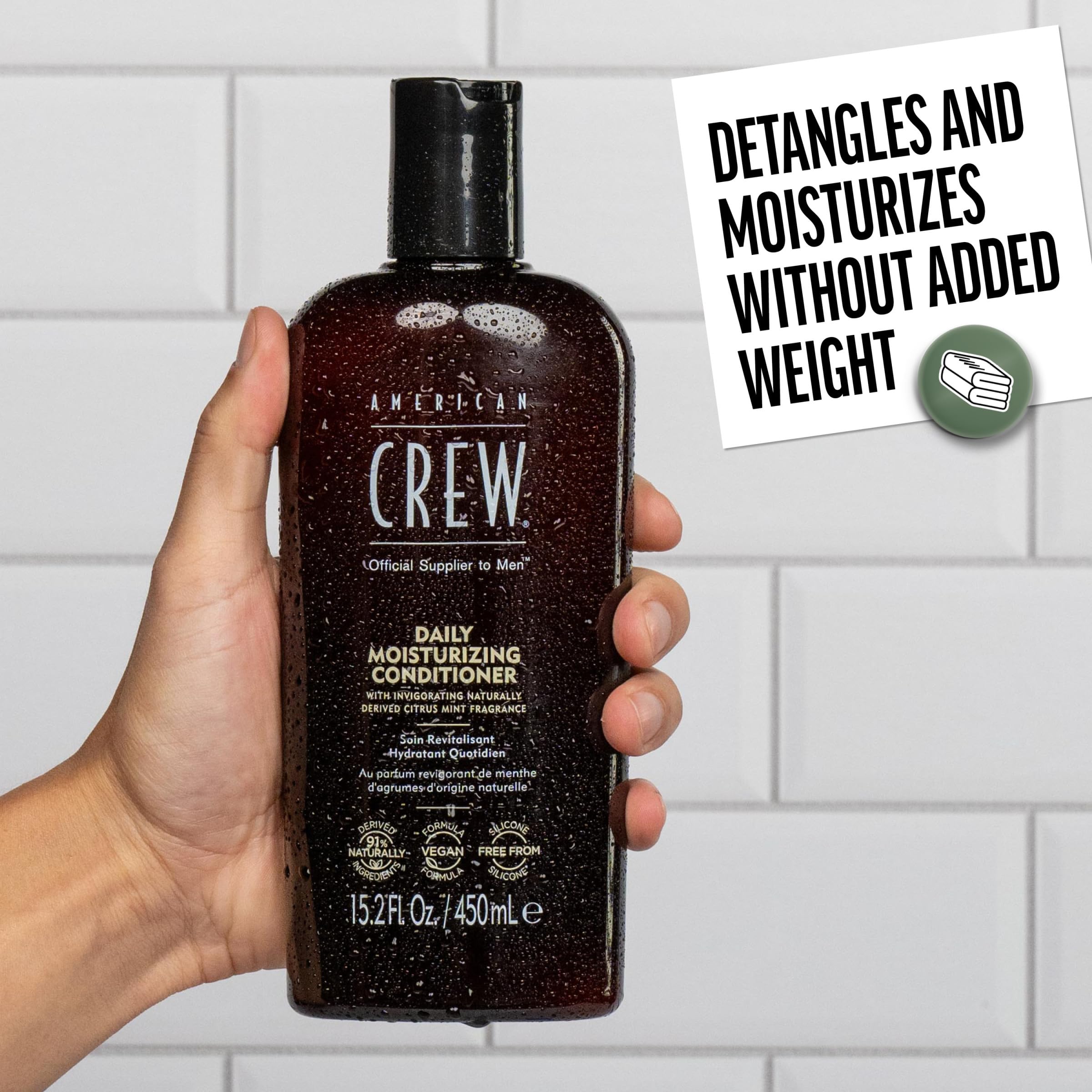 Manos aplicando el acondicionador American Crew distribuyen la crema de forma uniforme.