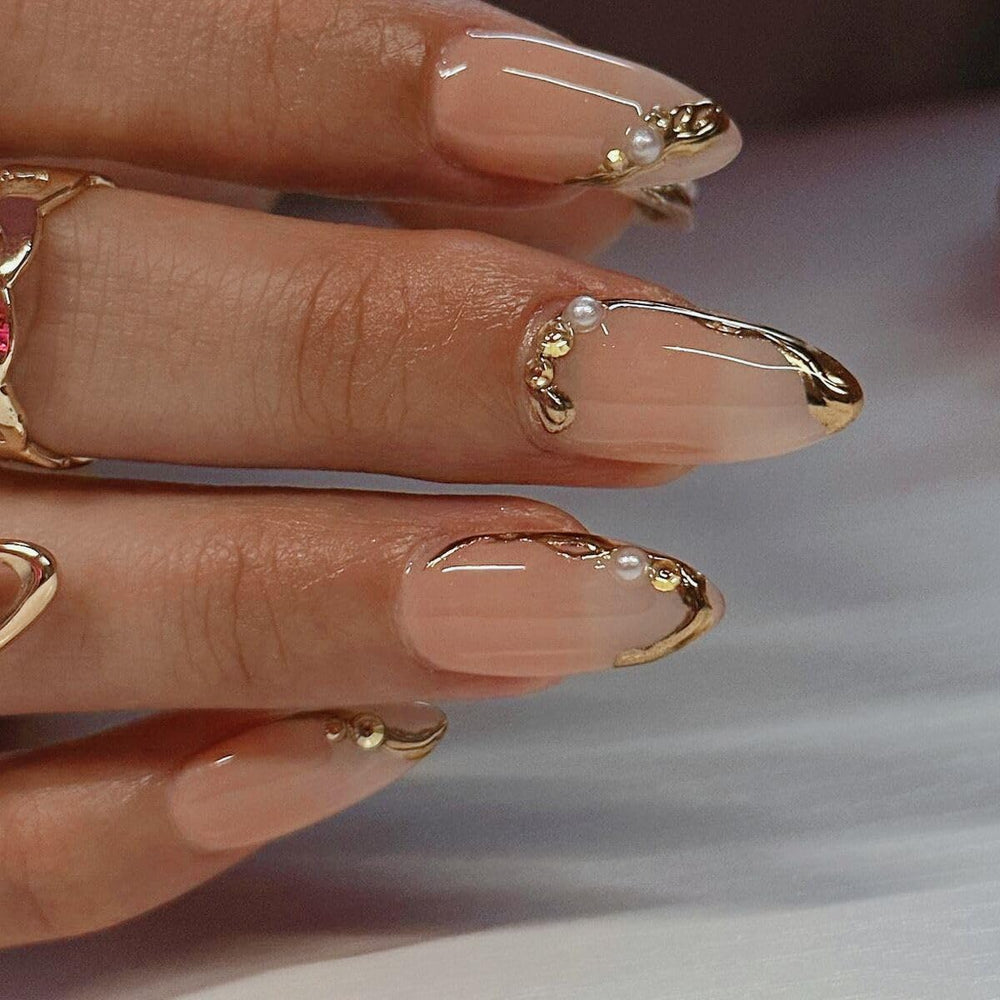 CTTHNBD uñas pegadas almendra frente-frances doradas con línea dorada, detalle distintivo.