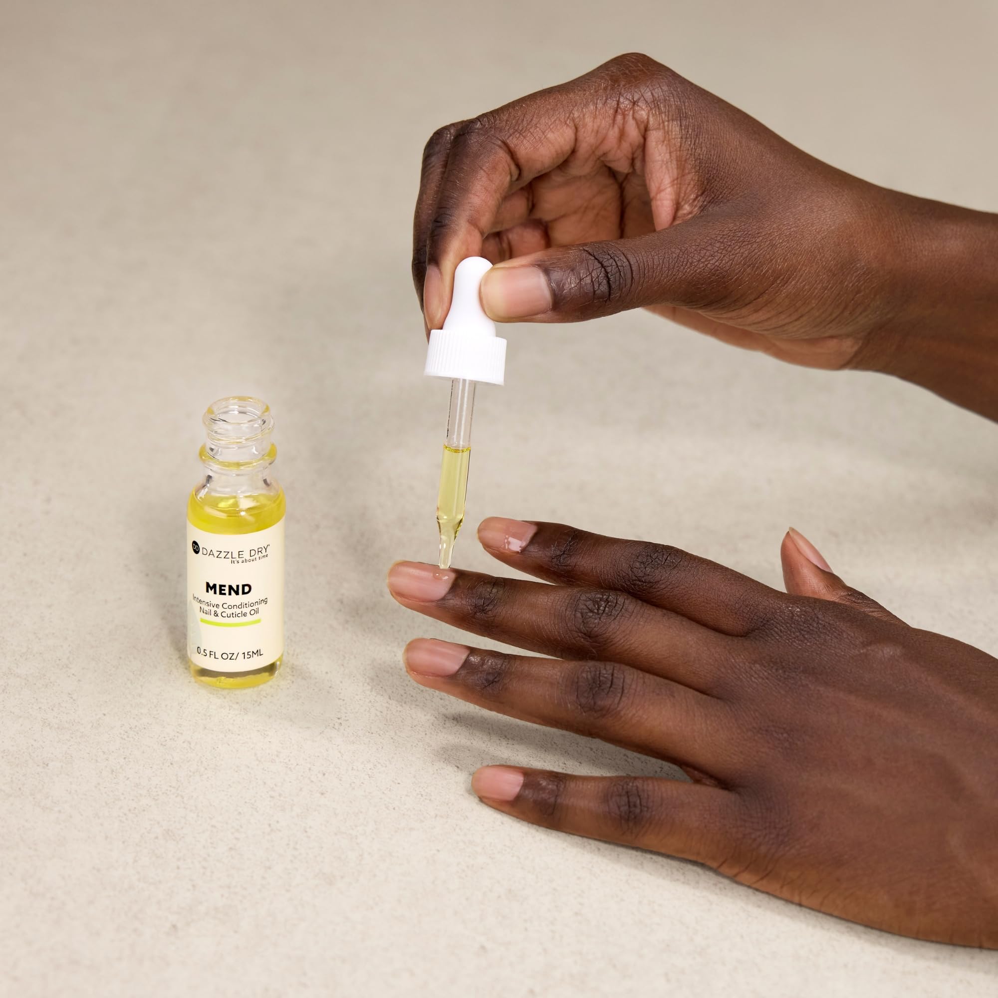 Gota de aceite de Dazzle Dry Mend Nail Repair Oil durante la rutina.