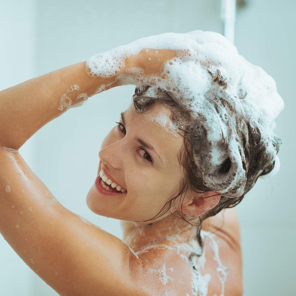 Ginger Lily Farms ZeroDerm Shampoo, escena-uso-en-bano: ideal para ritual diario de cuidado capilar