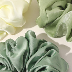 Ivyu scrunchie seda grande verde en la mano, demuestra elasticidad cómoda