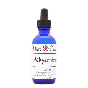 Julia's Essentials, aceite Abyssiniano, botella vertiendo, hidratación suave para piel y cabello