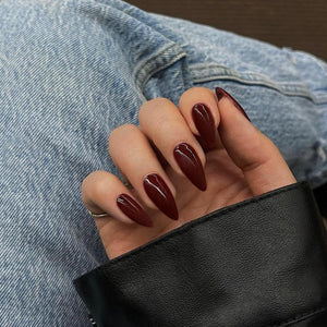 Uñas postizas de KQueenest en tono vino con forma almendra y brillo resistente.