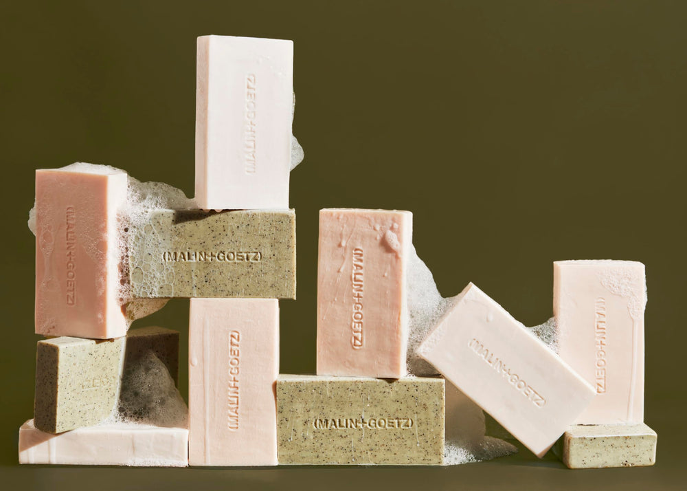 Barra exfoliante MALIN+GOETZ con vitaminas C y E para iluminar y nutrir la piel.