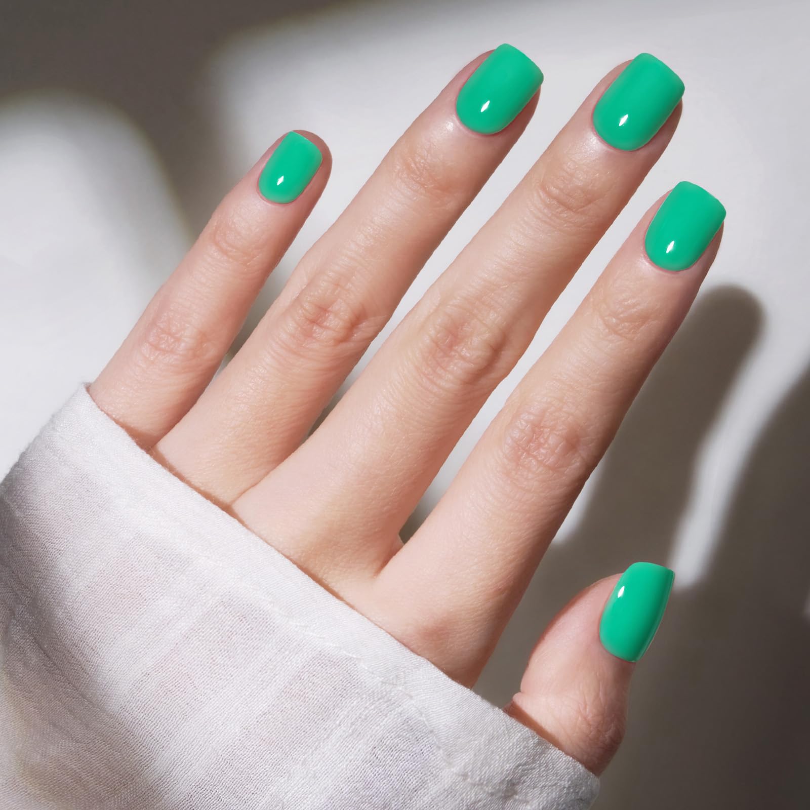 Modelones uñas presión verde vivo en mano, aplicación rápida para un look diario.