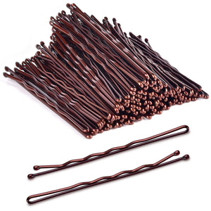 Pinzas Morgles grandes marrones junto a la caja, para cabello grueso y seguro.