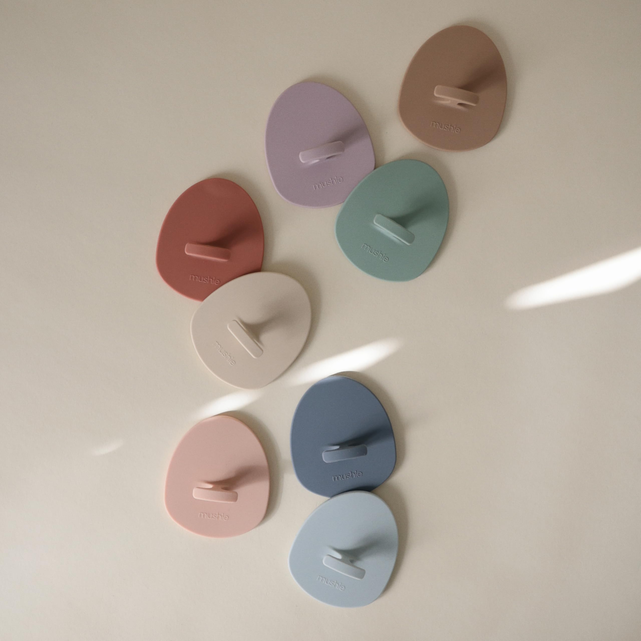 Mushie masajea la cabeza del bebé para eliminar costras con delicadeza.