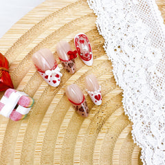 NZRAESTRS uñas valentinas French tip con corazones para un toque clásico.