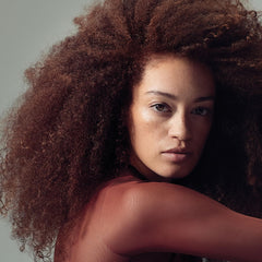Brillo natural en rizos gracias a la espuma hidratante de Paul Mitchell