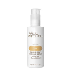 Paul Mitchell Round Trip Defining Serum sobre la encimera, empaque elegante para rizos definidos.