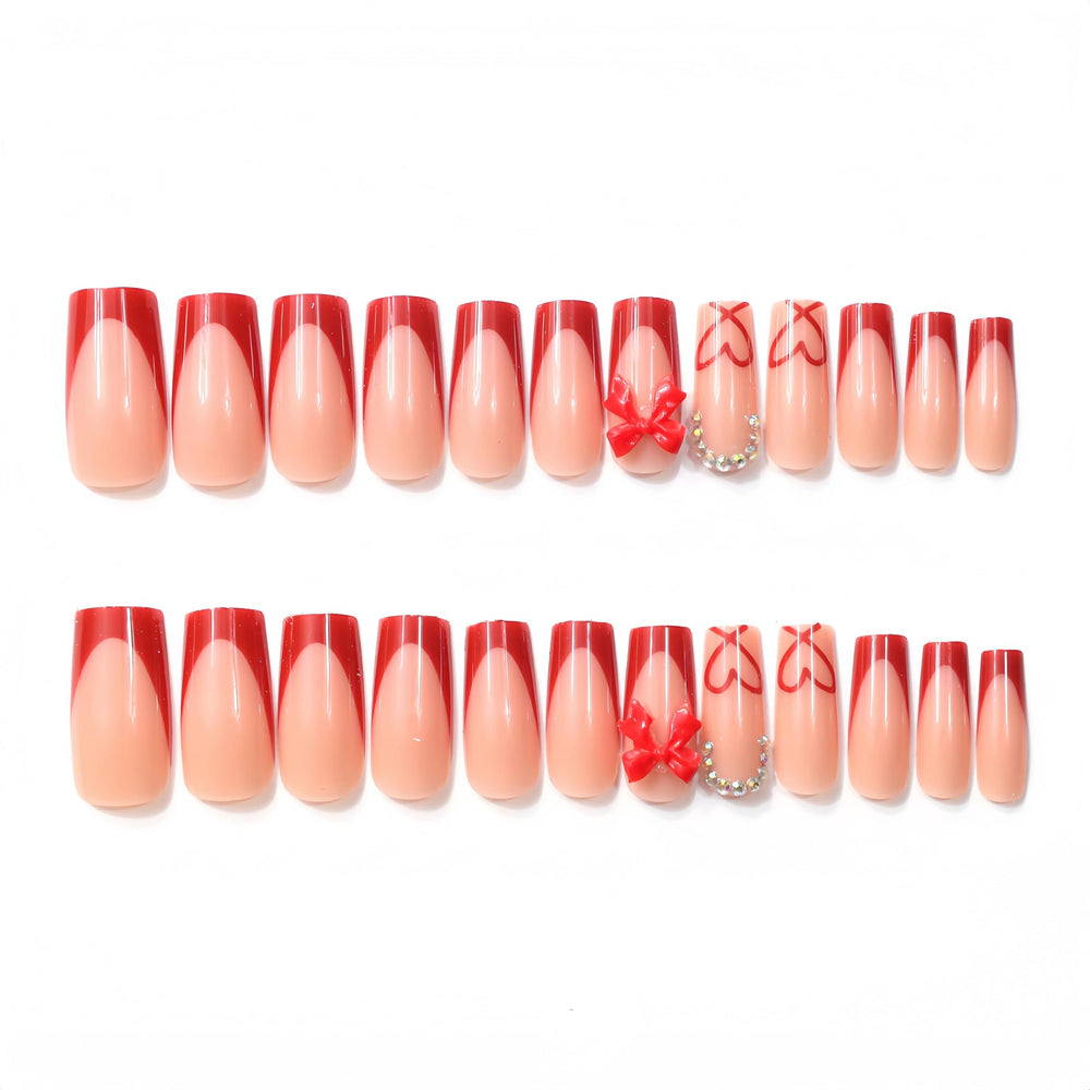 Quezadyl uñas francesas rojas con diseño corazones lazo, estilo elegante para citas.