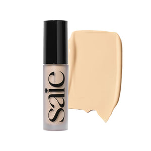 Corrector crema radiante de Saie en botella, cobertura ligera para un acabado natural.