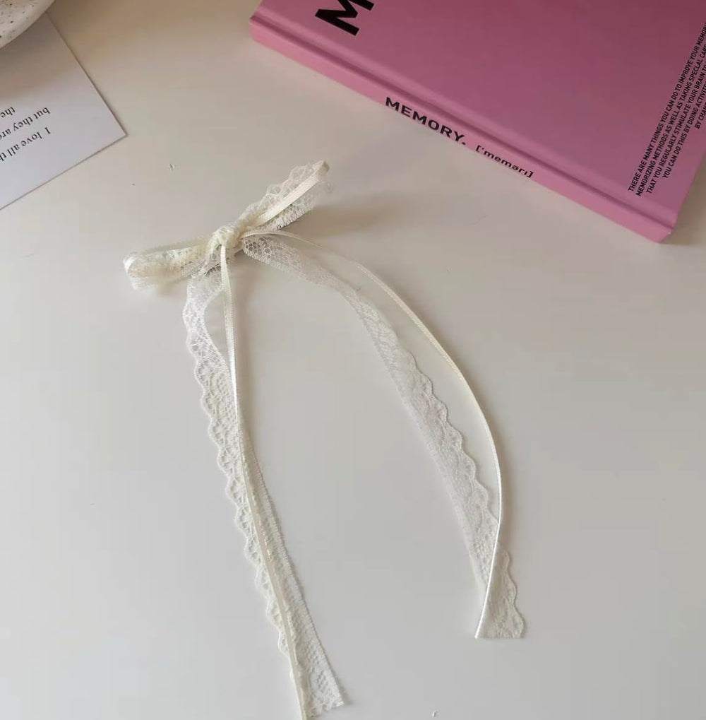 Lazo de Tobeffect en encaje blanco para looks suaves y femeninos.